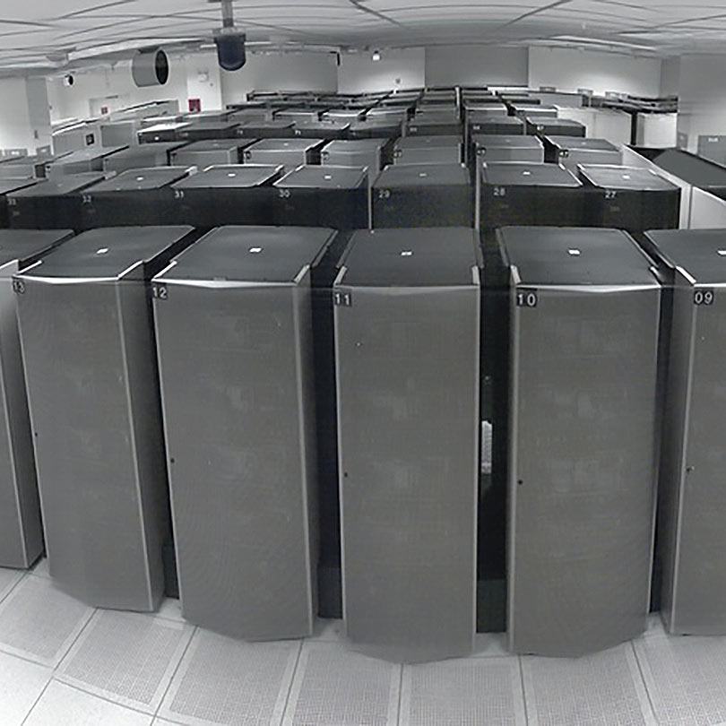 Large server room filled with rows and rows of tall server cabinets