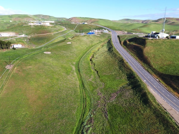 Areal drone view of road with rolling green hills